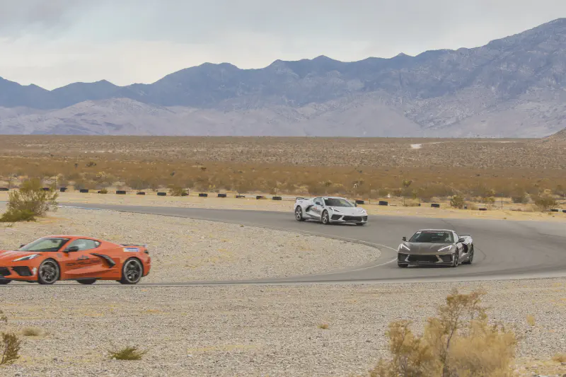 Three C8 Corvettes navigating a desert turn at Spring Mountain Motor Resort